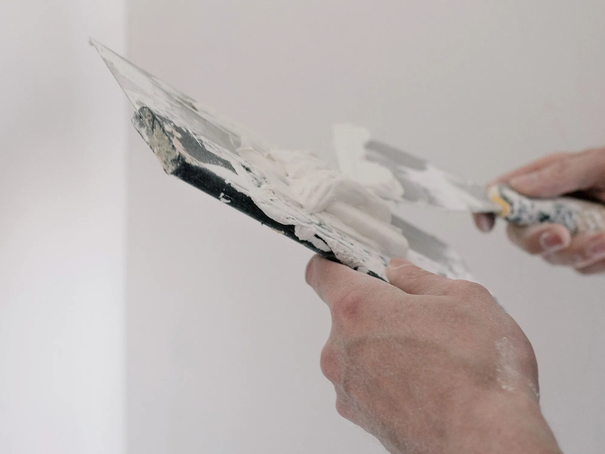 Dünner Materialauftrag mit der Kelle auf eine Innenwand.
