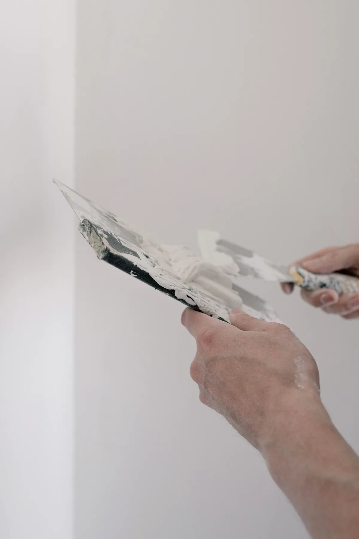 Material und Kelle für einen dünnen Aufbau an der Innenwand.